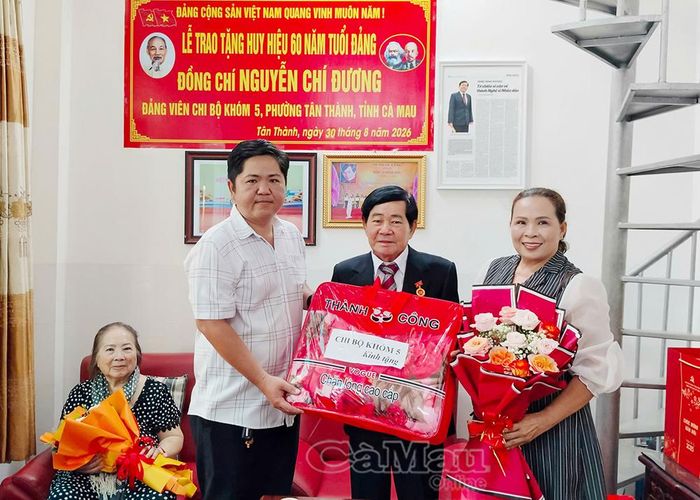 NSND Minh Đương nhận hoa và quà chúc mừng từ đại diện Chi uỷ Chi bộ Khóm 5 (phường Tân Thành).