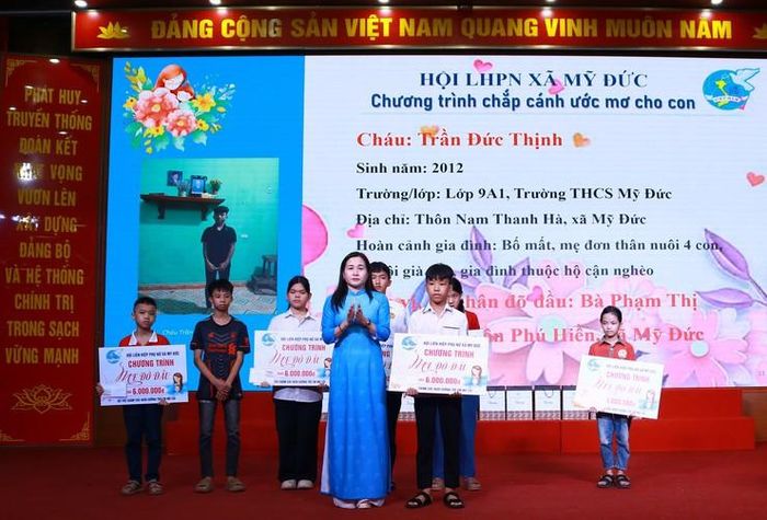 Đồng chí Đỗ Thị Hương, Chủ tịch Hội Liên hiệp phụ nữ xã Mỹ Đức trao học bổng “Mẹ đỡ đầu” cho học sinh Trần Đức Thịnh. Ảnh: Biên Phạm
