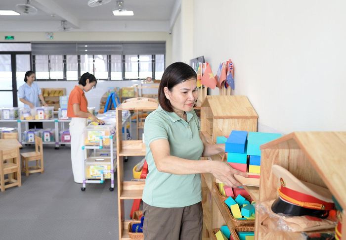 Giáo viên chuẩn bị dụng cụ học tập cho trẻ tại Trường Mầm non Quang Minh (xã Quang Minh).