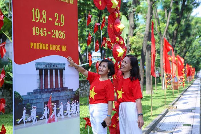 Người dân chụp ảnh bên pano trên phố Kim Mã. Ảnh: T.Anh.