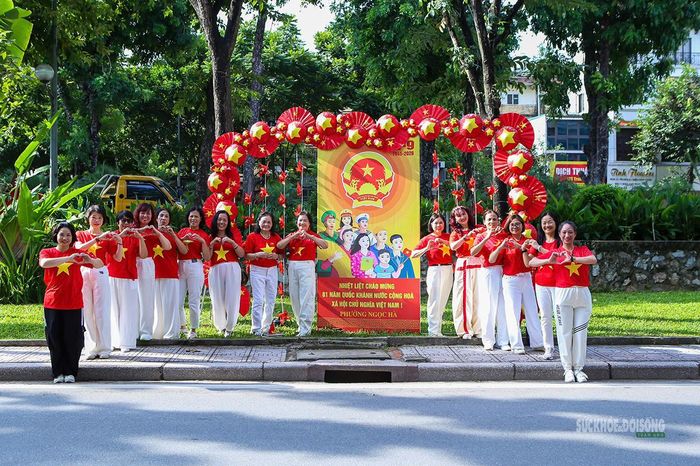 Nhóm phụ nữ trong áo cờ đỏ sao vàng chụp ảnh bên tiểu cảnh Quốc khánh. Ảnh: T.Anh.