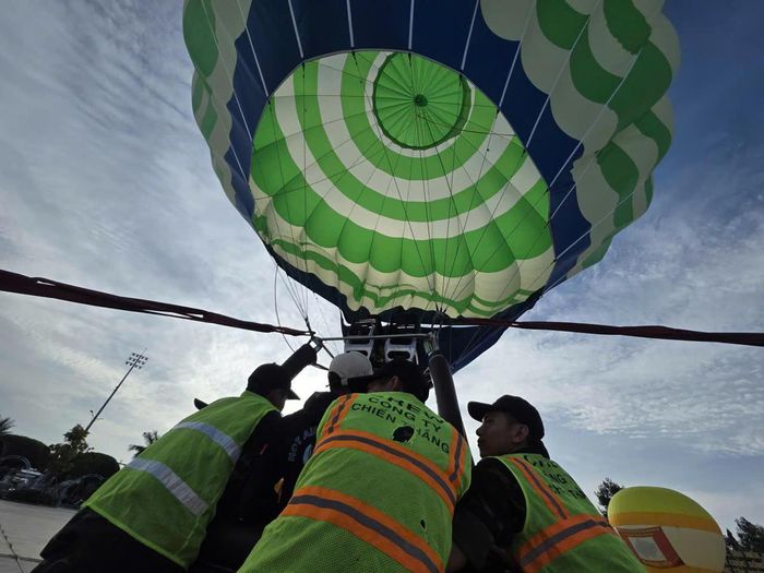 Các phi công và kỹ thuật viên sử dụng gas đốt tạo khí nóng bốc lên khi cầu lớn nhất Việt Nam phục vụ nhu cầu tham quan, trải nghiệm của người dân và du khách. Ảnh: Nguyên Du