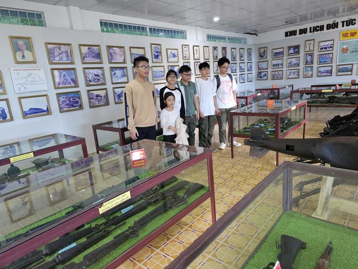 Sau khi khám phá hệ thống hang động trên đồi Tức Dụp và nghe những câu chuyện lịch sử, xuống chân đồi, du khách có thể tham quan Nhà Truyền thống với những hình ảnh, tư liệu và hiện vật gợi lại một thời chiến đấu gian khổ của thế hệ cha ông. Ảnh: H.A