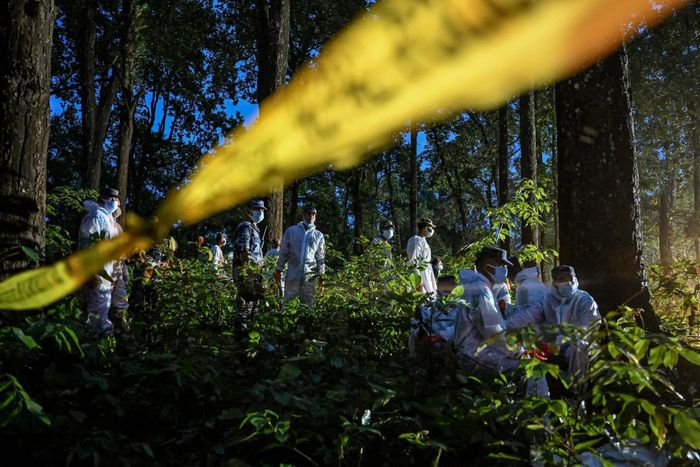 Lực lượng chức năng chôn cất các thi thể tại rừng Devghat, Chitwan (Nepal) ngày 30/8. Ảnh: Reuters, New York Times.