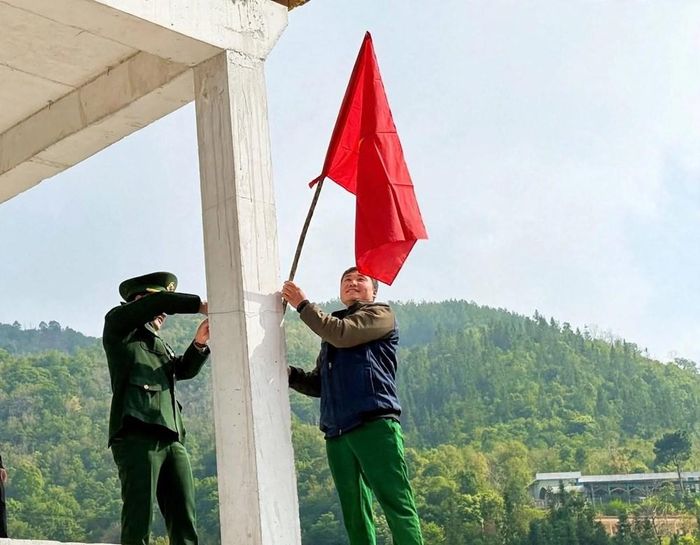 Người dân cùng lực lượng chức năng treo cờ Tổ quốc, tạo không khí trang trọng, phấn khởi trên các bản làng biên giới