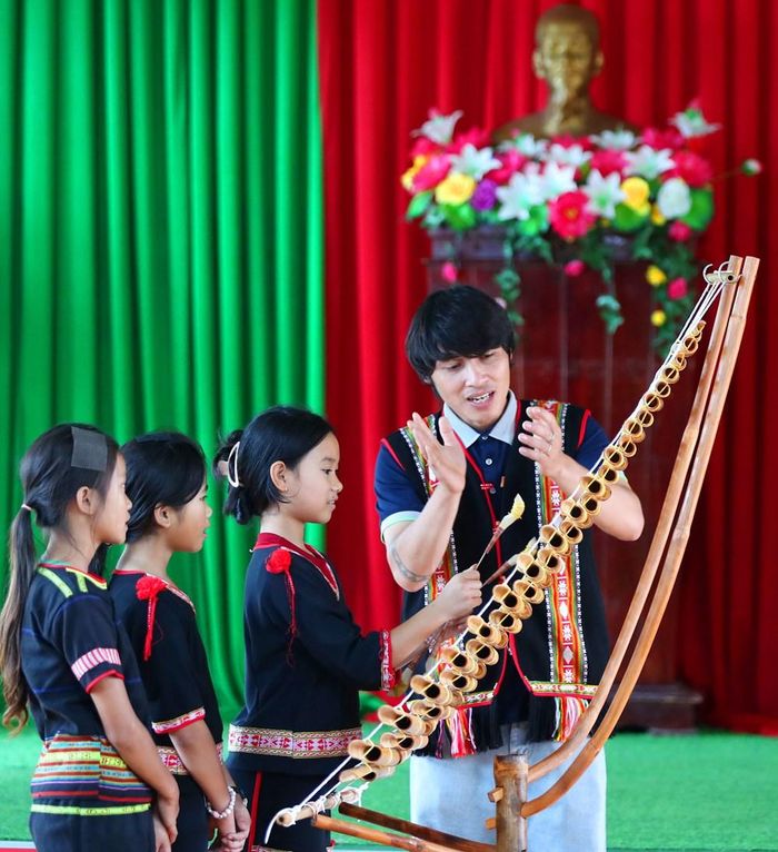 Nghệ nhân tận tình hướng dẫn các nữ sinh cách diễn tấu đàn t’rưng, góp phần trao truyền những thanh âm văn hóa truyền thống cho thế hệ trẻ
