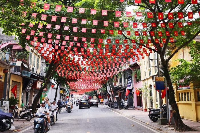 Cờ Tổ quốc và cờ Đảng trang hoàng rực rỡ trên phố Hàng Than. Ảnh: Minh Đức – TTXVN