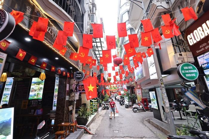 Cờ Tổ quốc và cờ Đảng trang hoàng rực rỡ ở Ngõ Huyện, phường Hoàn Kiếm. Ảnh: Minh Đức – TTXVN