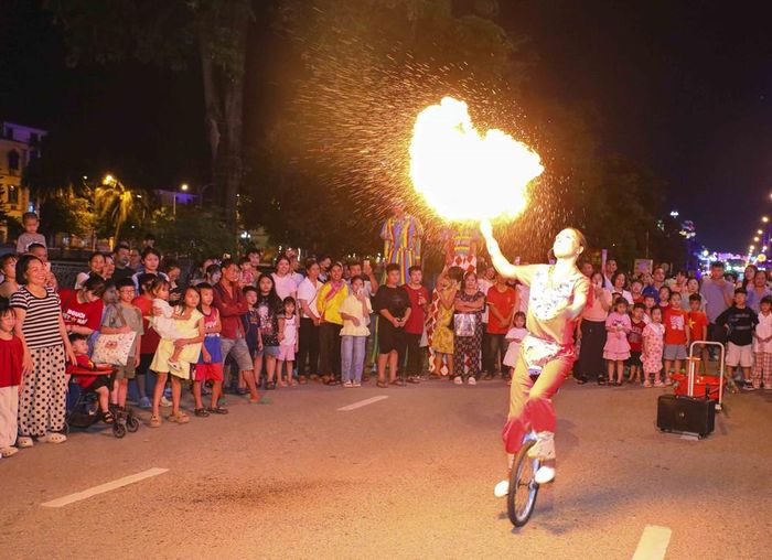 Một tiết mục xiếc đường phố với màn phun lửa thu hút đông đảo người dân và du khách theo dõi. Ảnh: Xuân Tư - TTXVN
