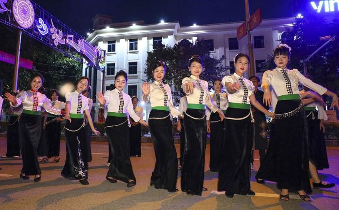 Các thành viên câu lạc bộ trình diễn dân vũ trong trang phục truyền thống của dân tộc Thái trên đường phố Điện Biên Phủ. Ảnh: Xuân Tư - TTXVN