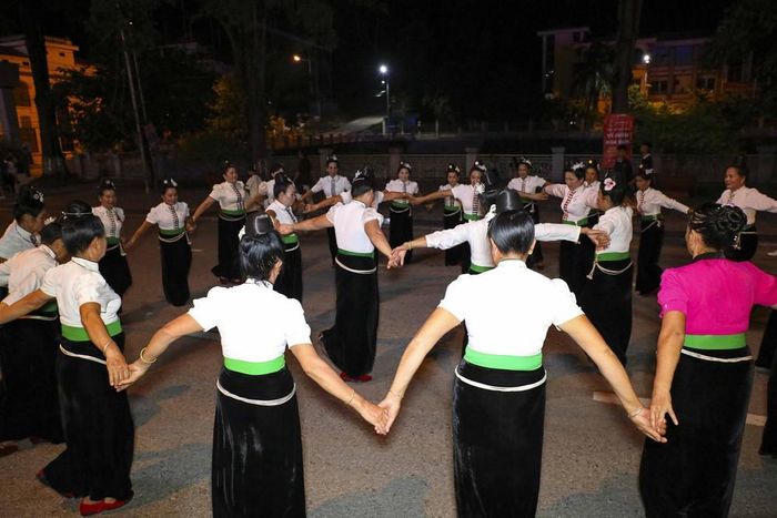 Các thành viên câu lạc bộ dân vũ nắm tay vòng xòe đoàn kết trên đường phố. Ảnh: Xuân Tư - TTXVN