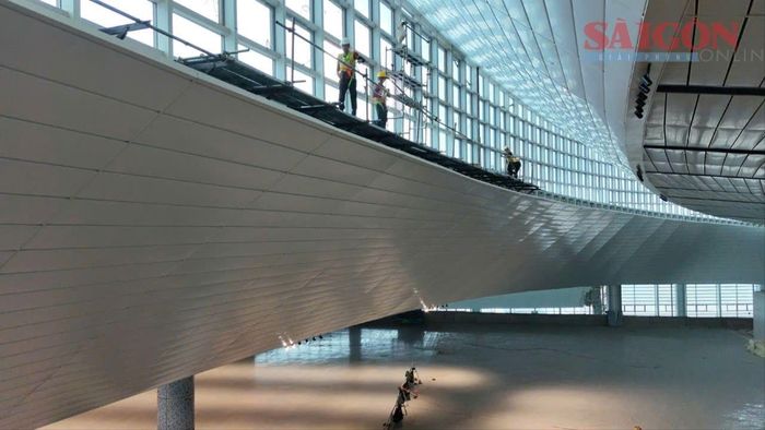 Nhân viên kỹ thuật thi công hoàn thiện vách kính nhà ga hành khách. Ảnh: XUÂN TRUNG