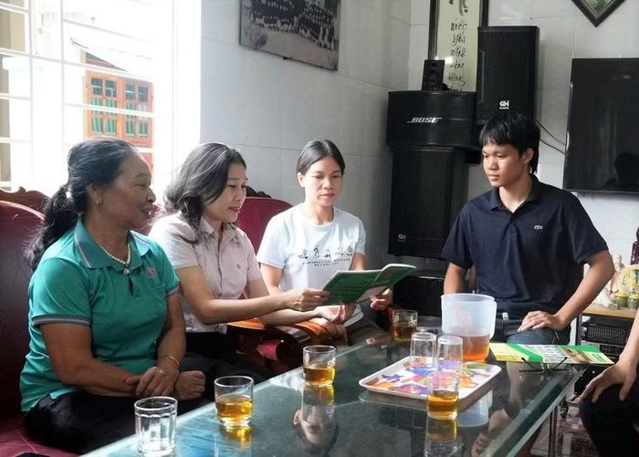 Cán bộ Phòng Giao dịch Ngân hàng Chính sách xã hội Nghi Lộc (Nghệ An) hướng dẫn thủ tục vay vốn cho một gia đình có 2 con đang học đại học. Ảnh: Hồ Lài