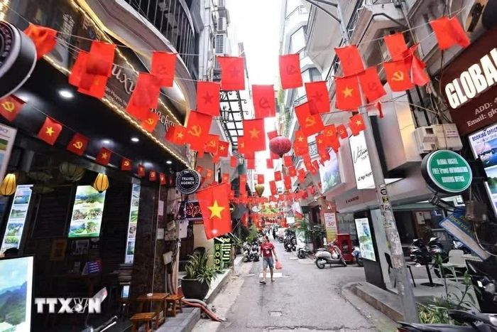 Cờ Tổ quốc và cờ Đảng trang hoàng rực rỡ ở Ngõ Huyện, phường Hoàn Kiếm. (Nguồn: TTXVN)