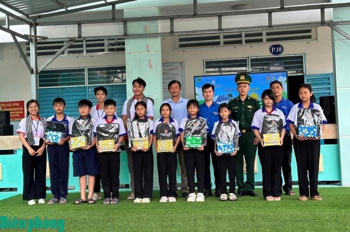 Cán bộ Đồn Biên phòng Vĩnh Gia, Bộ đội Biên phòng tỉnh An Giang và đại diện Đoàn Thanh niên xã Vĩnh Gia (tỉnh An Giang), Liên Chi hội Sinh viên An Giang-Đại học Cần Thơ trao học bổng cho các em học sinh có hoàn cảnh khó khăn trên địa bàn. Ảnh: Đơn vị cung cấp