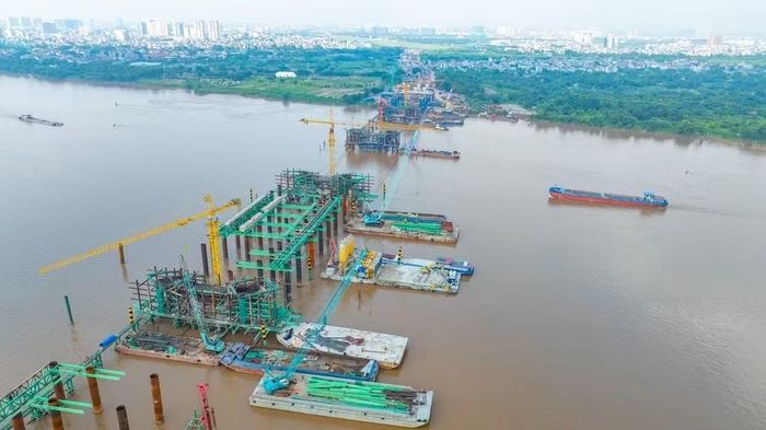 Toàn cảnh công trường cầu Trần Hưng Đạo, nhiều mũi thi công đang được triển khai đồng loạt trên bờ và giữa sông Hồng. Ảnh: TL