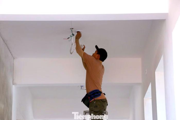 Những chiếc bóng đèn trong phòng học, hành lang đang được công nhân hoàn thiện để phục vụ ngày khai giảng 5/9.