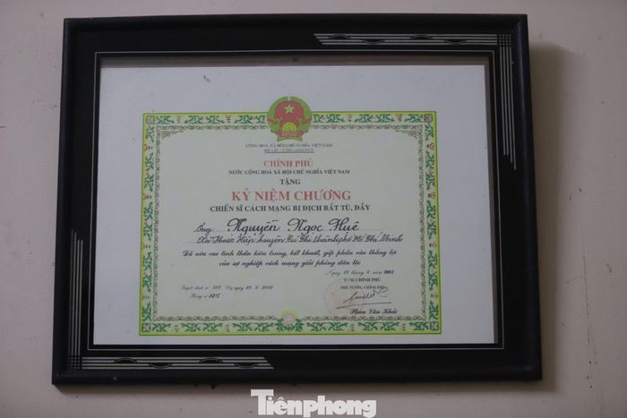 Kỷ niệm chương “Chiến sĩ cách mạng bị địch bắt tù, đày” được gia đình bà Huệ lưu giữ, treo trang trọng trên tường nhà.