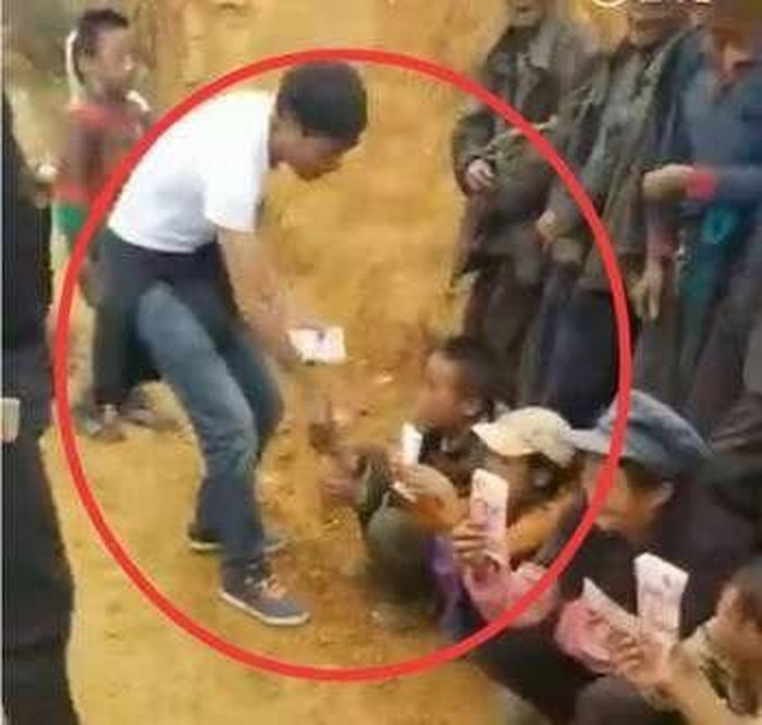 "Kuaishou Jiege" và "Kuaishou Heishu" dàn dựng cảnh phát tiền từ thiện cho người dân nghèo. Ảnh: CGTN