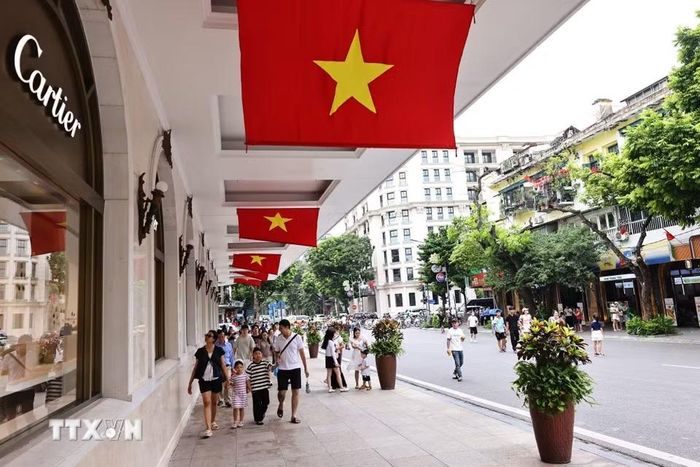 Cờ Tổ quốc cỡ lớn được bố trí tại khu vực trung tâm thương mại Tràng Tiền Plaza. (Ảnh: Minh Đức/TTXVN)