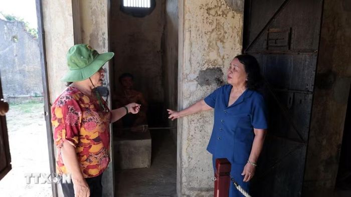 Anh hùng lực lượng vũ trang nhân dân Võ Thị Hóa (áo xanh) và bà Phạm Thị Thu, những người từng bị giam cầm tại Nhà lao Hội An, thăm lại khu vực xà lim, hay còn gọi là khu biệt giam. (Ảnh: Đỗ Trưởng/TTXVN)
