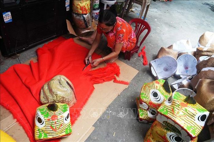 Cắt vải để trang trí cho đầu lân ở cở sở ông Cao Xuân Dũng, phường Phú Xuân, thành phố Huế.