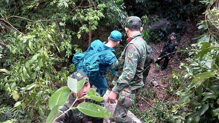 Đội Tìm kiếm, quy tập hài cốt liệt sĩ tỉnh Khánh Hòa và dân quân địa phương hỗ trợ nhau vượt qua khộp đá nguy hiểm. Ảnh: Xuân Triệu/TTXVN