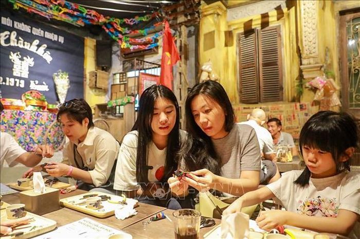 Khách tham quan trải nghiệm làm dép lốp.