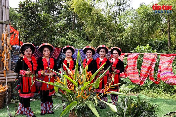 Đồng bào trong trang phục truyền thống rực rỡ chụp ảnh lưu niệm tại không gian chợ phiên vùng cao.