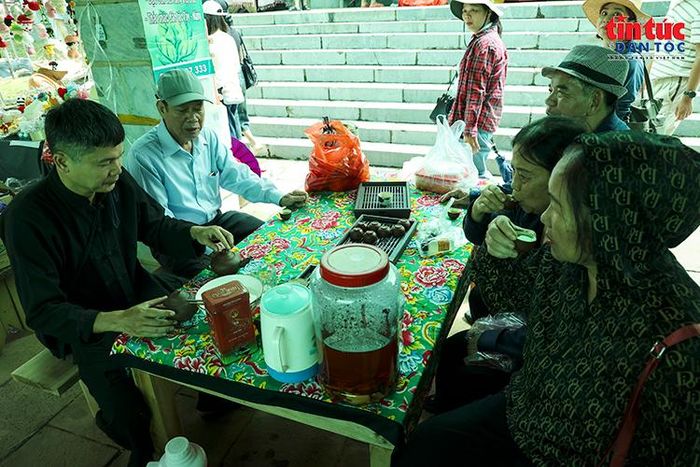 Người dân và du khách nghỉ chân, thưởng trà giữa không gian chợ phiên nhộn nhịp.