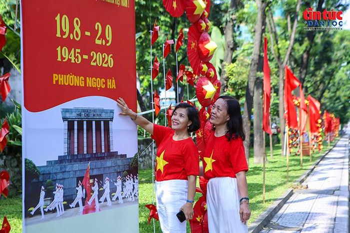 Người dân lưu lại hình ảnh kỷ niệm bên pano chào mừng Cách mạng Tháng Tám và Quốc khánh 2/9.