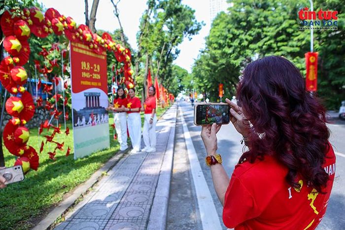 Người dân ghi lại những khoảnh khắc vui chơi bên không gian cờ hoa rực rỡ.