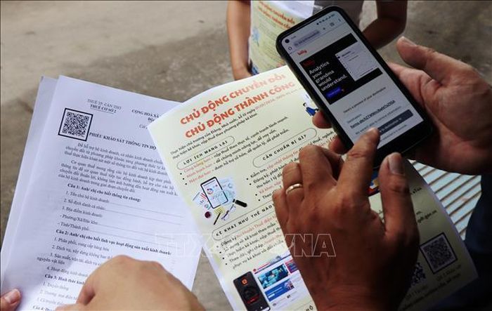 Hộ kinh doanh cài đặt phần mềm eTax Mobile tự kê khai thuế. Ảnh: Thu Hiền/TTXVN