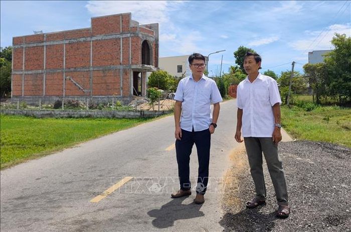 Gia đình ông Đinh Ngọc Tài (bên phải) đã tình nguyện hiến hơn 30 m2 đất mặt tiền để mở rộng đường giao thông nông thôn tại thôn Tam Giang (xã Núi Thành, thành phố Đà Nẵng). Ảnh: Quốc Dũng/TTXVN