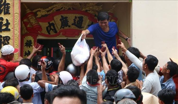 Các nghi thức tại miếu Ông Bổn thể hiện quan niệm dân gian về việc bố thí, chia sẻ lễ vật và tạo không gian để người dân gặp gỡ, giao lưu và cùng nhau đón nhận những điều tốt lành. Ảnh: Duy Khương/TTXVN
