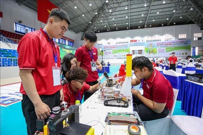                                   Học sinh phối hợp, trao đổi phương án lập trình và điều khiển robot. Ảnh: TTXVN 