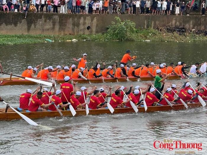 Người dân đứng dày đặc hai bên bờ sông xem các thuyền bơi tranh tài.