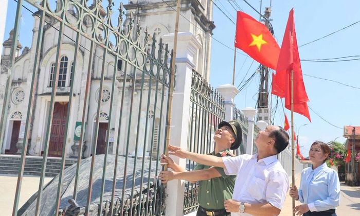  Đại tá Nguyễn Quốc Vương, Phó Giám đốc Công an tỉnh cùng Ban Hành giáo Giáo xứ Thanh Giã treo cờ Tổ quốc. 