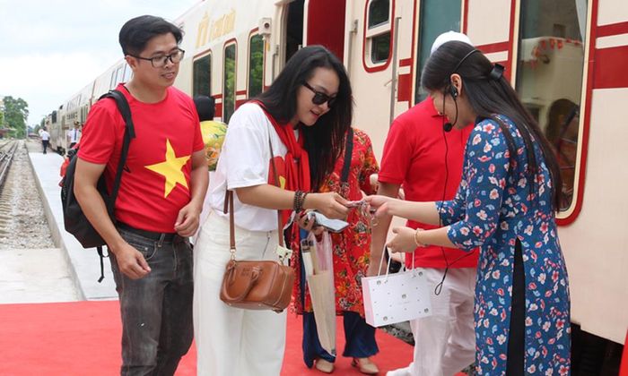 Khách du lịch hào hứng đón nhận quà tặng lưu niệm in hình di sản văn hóa Kinh Bắc.