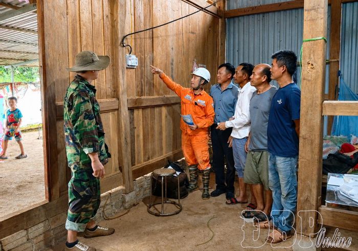 Cán bộ Điện lực Na Sang hướng dẫn người dân bản Huổi Xuân sử dụng điện an toàn.