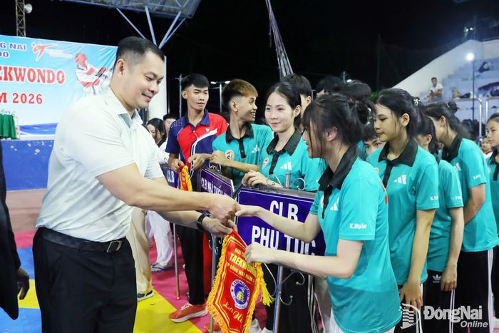Ban tổ chức tặng cờ lưu niệm cho các đoàn tham dự. Ảnh: Huy Anh