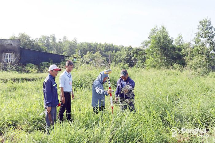 Lực lượng chức năng xã An Phước đo đạc, kiểm kê tài sản đất đai thu hồi làm dự án.