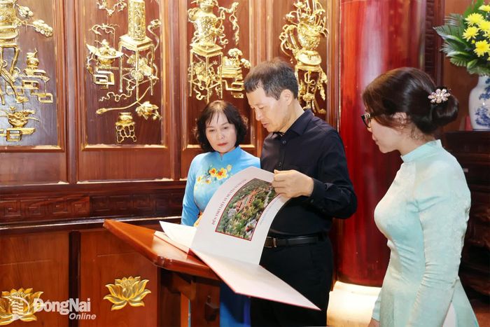 Đồng chí Bí thư Thành ủy Vũ Hồng Văn xem danh sách liệt sĩ tại Đền thờ Liệt sĩ Xuân Lộc. Ảnh: Ngọc Hoàng