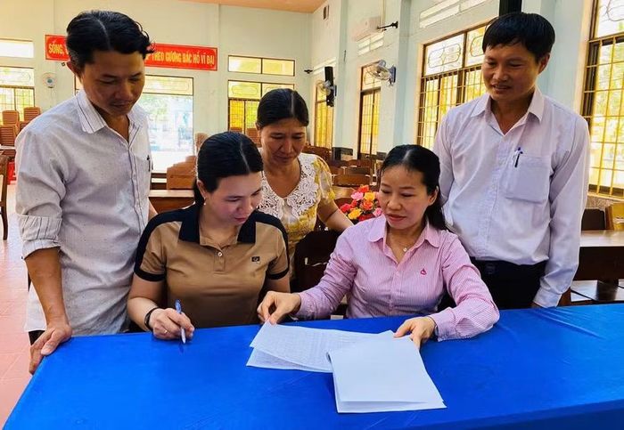  Cán bộ Phòng giao dịch Ngân hàng CSXH Hoài Nhơn hướng dẫn người dân vay vốn tín dụng chính sách. Ảnh: T.S 
