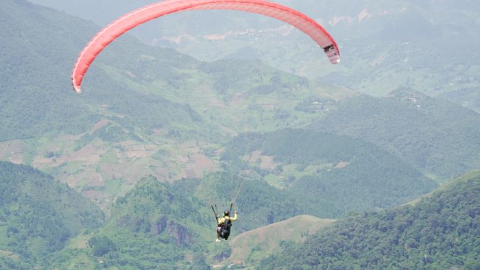 Du khách trải nghiệm bay dù lượn giữa núi rừng Mù Cang Chải.
