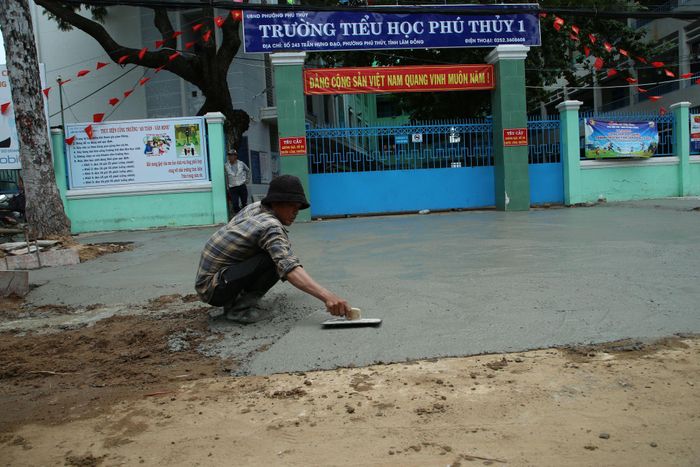 Công nhân Công ty Trường Long đang gấp rút hoàn thiện các hạng mục trước Trường Tiểu học Phú Thủy 1 để kịp cho các em học sinh khai giảng vào ngày 5/9