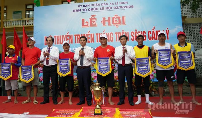 Lãnh đạo xã Lệ Ninh trao cờ lưu niệm cho các đội thuyền bơi - Ảnh: L.Chi