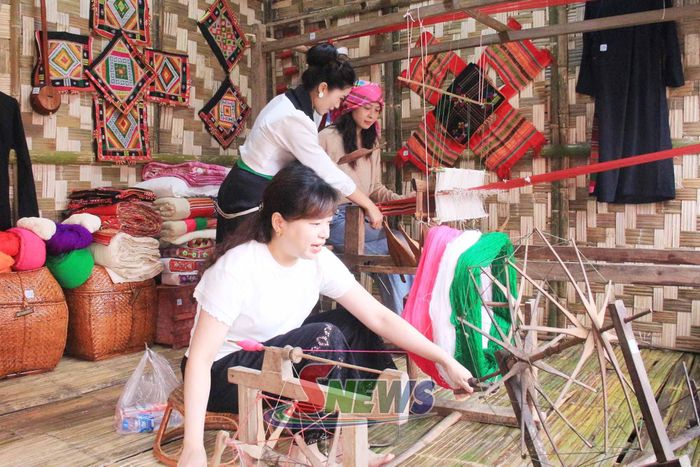 Du khách trải nghiệm dệt thổ cẩm.
