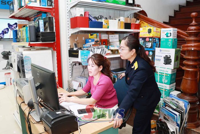 Công chức Thuế cơ sở 2 hướng dẫn hộ kinh doanh xã Mai Sơn kê khai thuế điện tử.