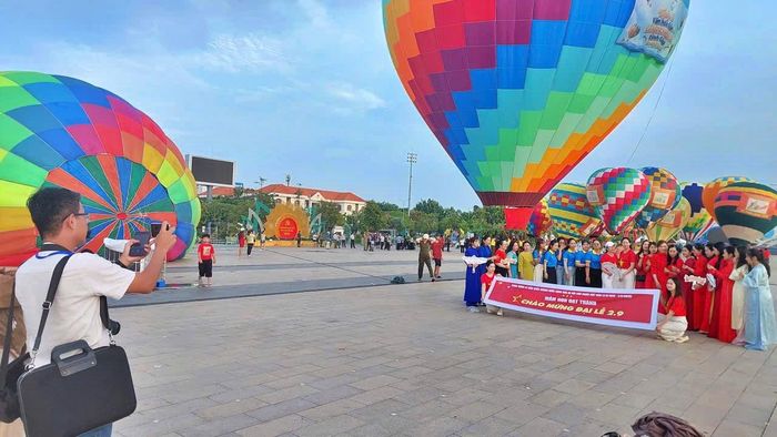 Du khách chụp ảnh kỷ niệm bên những quả khinh khí cầu đầy màu sắc tại Quảng trường Hùng Vương.